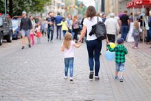 Vrouw met dochter en zoon lopend door de winkelstraat