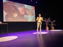 Wethouder van Ginderen op het podium bij de vertoning van mama mag ik naar huis toe